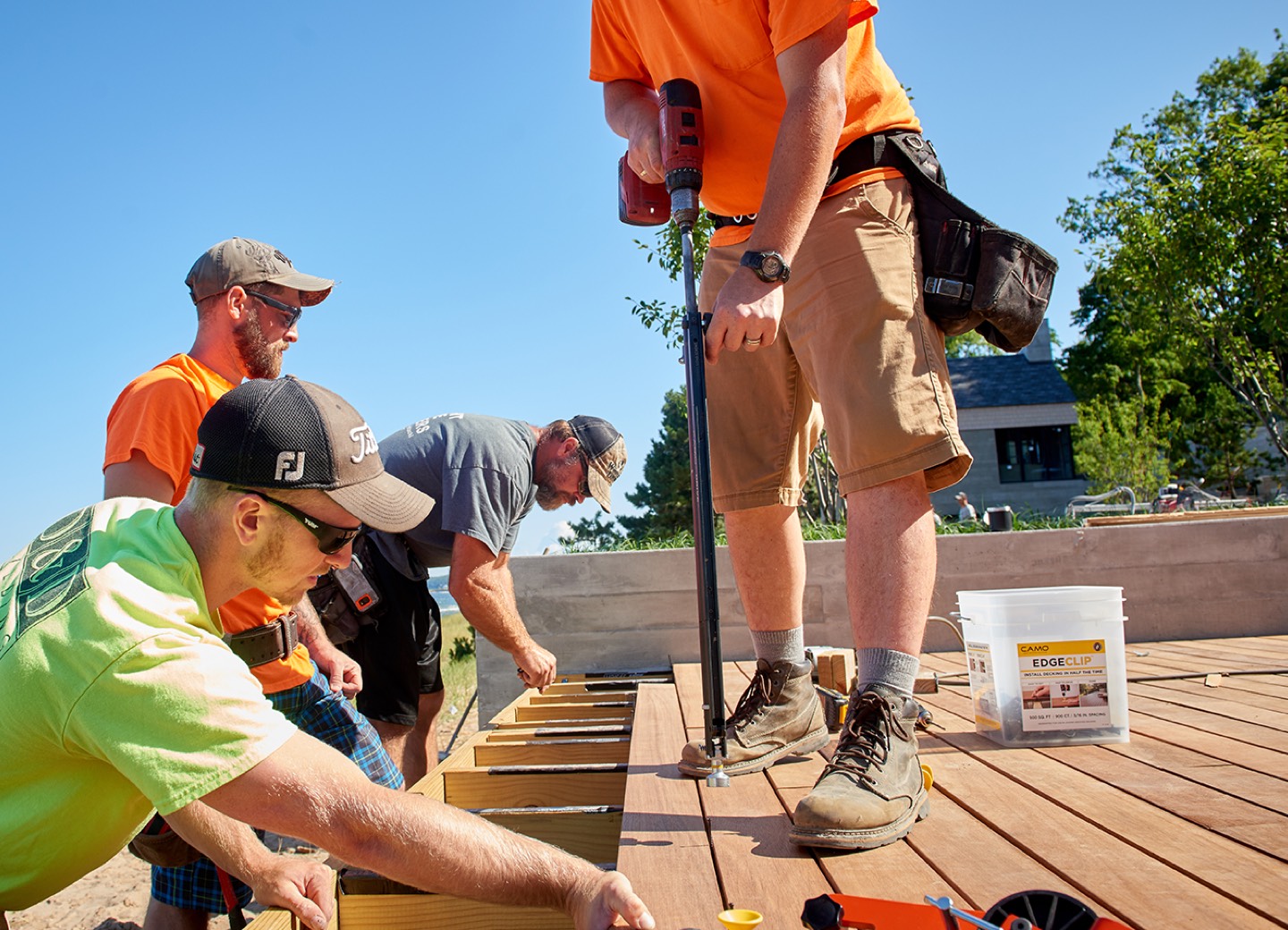 Crew installing deck boards with CAMO clips and DRIVE